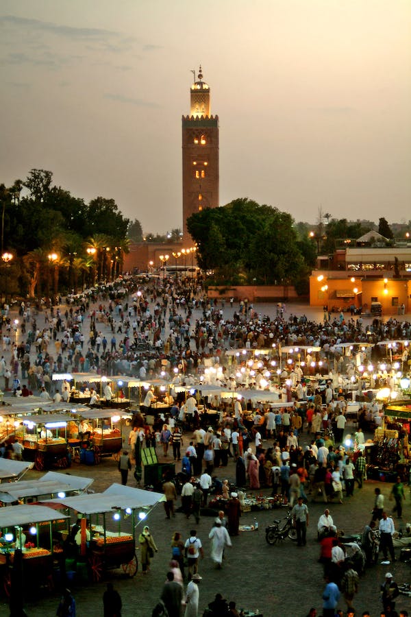 Grande place animee avec une grande mosquee derriere la place