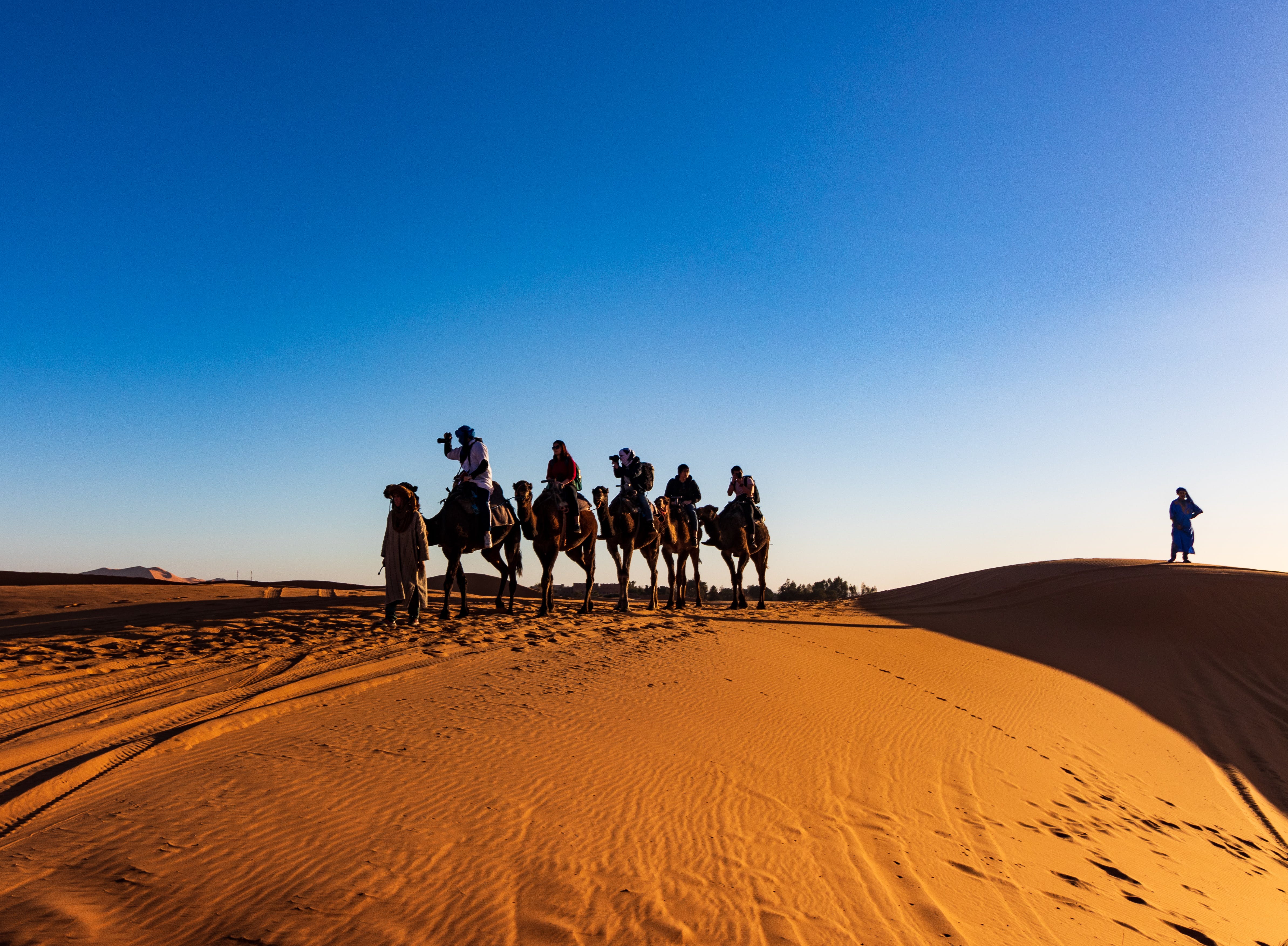 Un groupe de personnes chevauchant un chameau dans le d&eacutesert.
